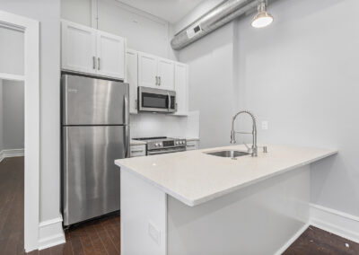 Newly renovated kitchen with island and stainless steel appliances at Dickinson Lofts luxury lofts for rent in Grays Ferry