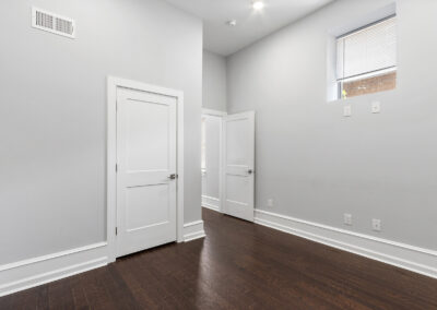 Empty interior room with high ceilings and hardwood floors at Dickinson Lofts luxury lofts for rent in Grays Ferry