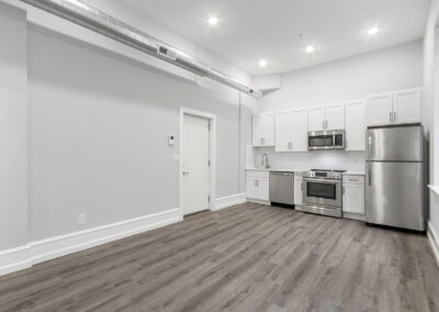 Newly renovated kitchen and living space with hardwood floors and high ceilings at Dickinson Lofts luxury lofts for rent in Grays Ferry