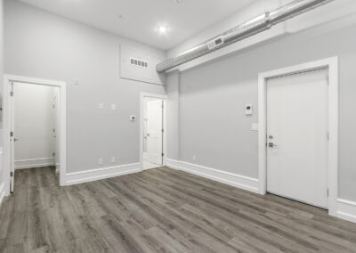 Living space with hardwood floors and high ceilings at Dickinson Lofts luxury lofts for rent in Grays Ferry