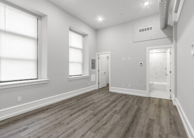 Interior open living space with windows for natural light and hardwood floors at Dickinson Lofts luxury lofts for rent