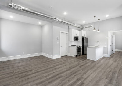 Newly renovated kitchen and living room with hardwood floors and high ceilings at Dickinson Lofts luxury lofts for rent in Grays Ferry