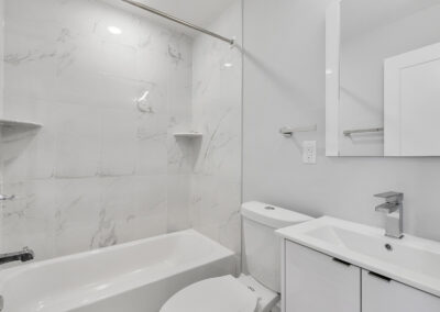 Newly renovated bathroom with shower/tub combo, toilet, and sink at Dickinson Lofts luxury lofts for rent in Grays Ferry