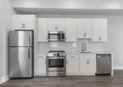 Kitchen with white cabinetry, hardwood floors, and stainless steel appliances at Dickinson Lofts luxury lofts for rent