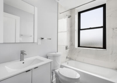 Newly renovated bathroom with sink, shower/tub combo, and toilet at Dickinson Lofts luxury lofts for rent in Grays Ferry